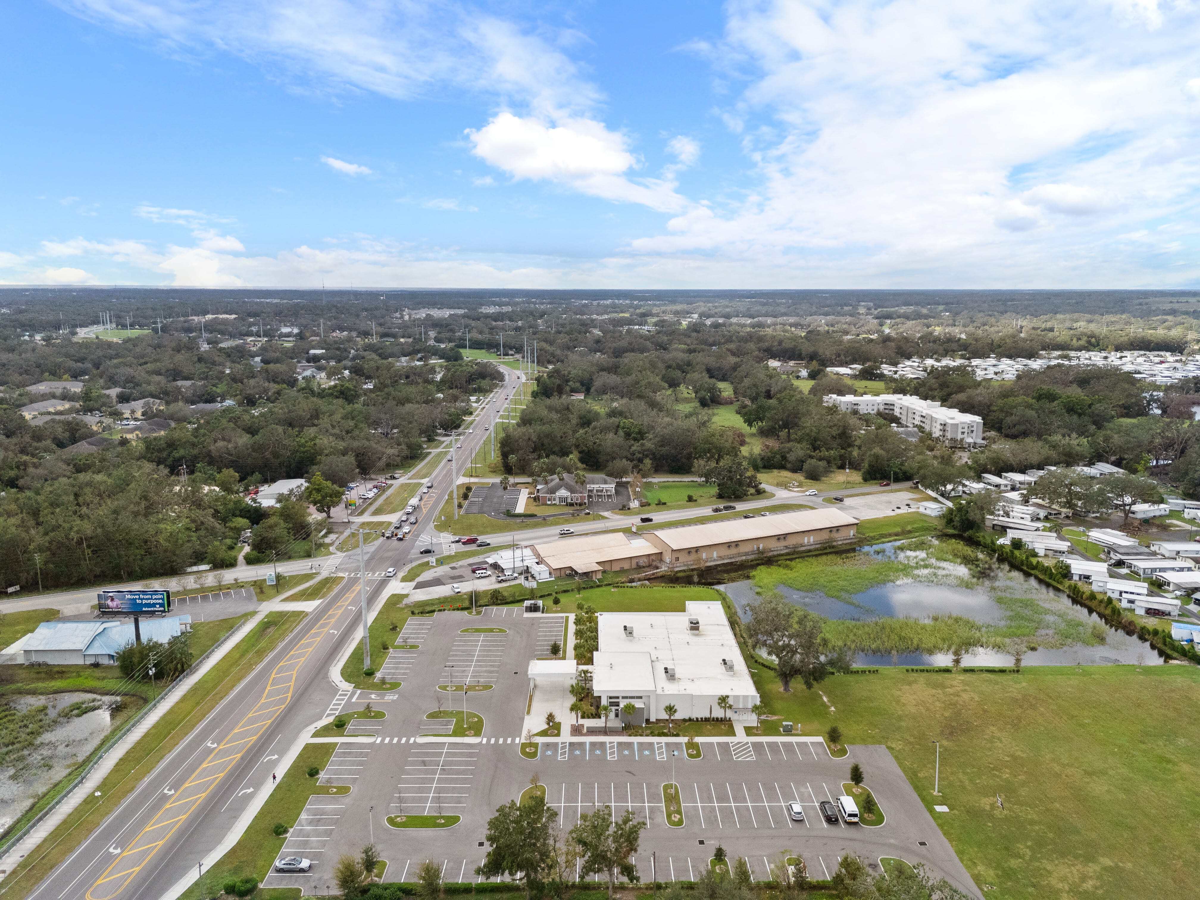 Southwest-facing aerial view of Zephyrhills VA Clinic and nearby intersections with green space and water