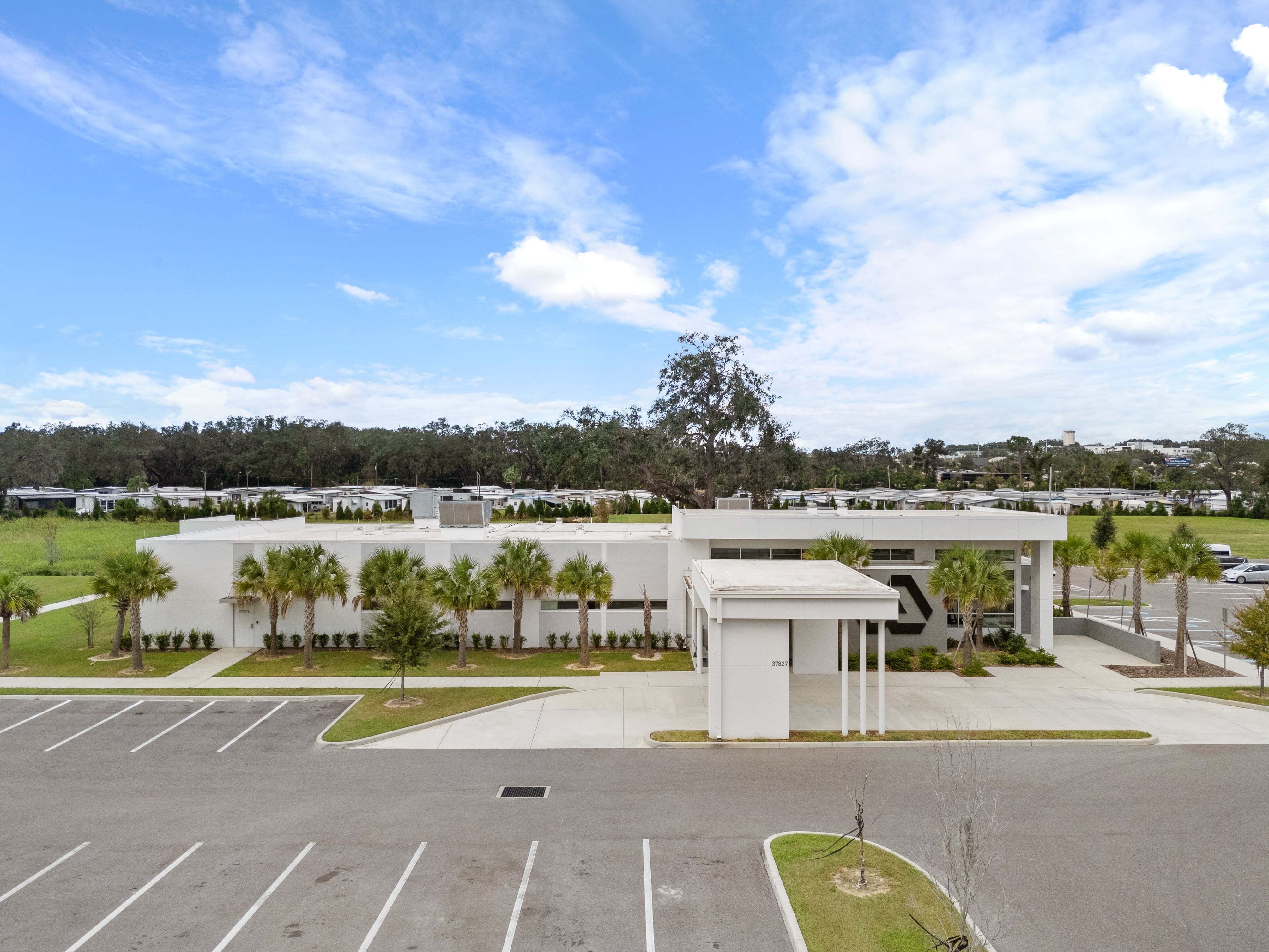 Broad view of VA clinic entrance drive with visible flagpole and pedestrian crosswalk