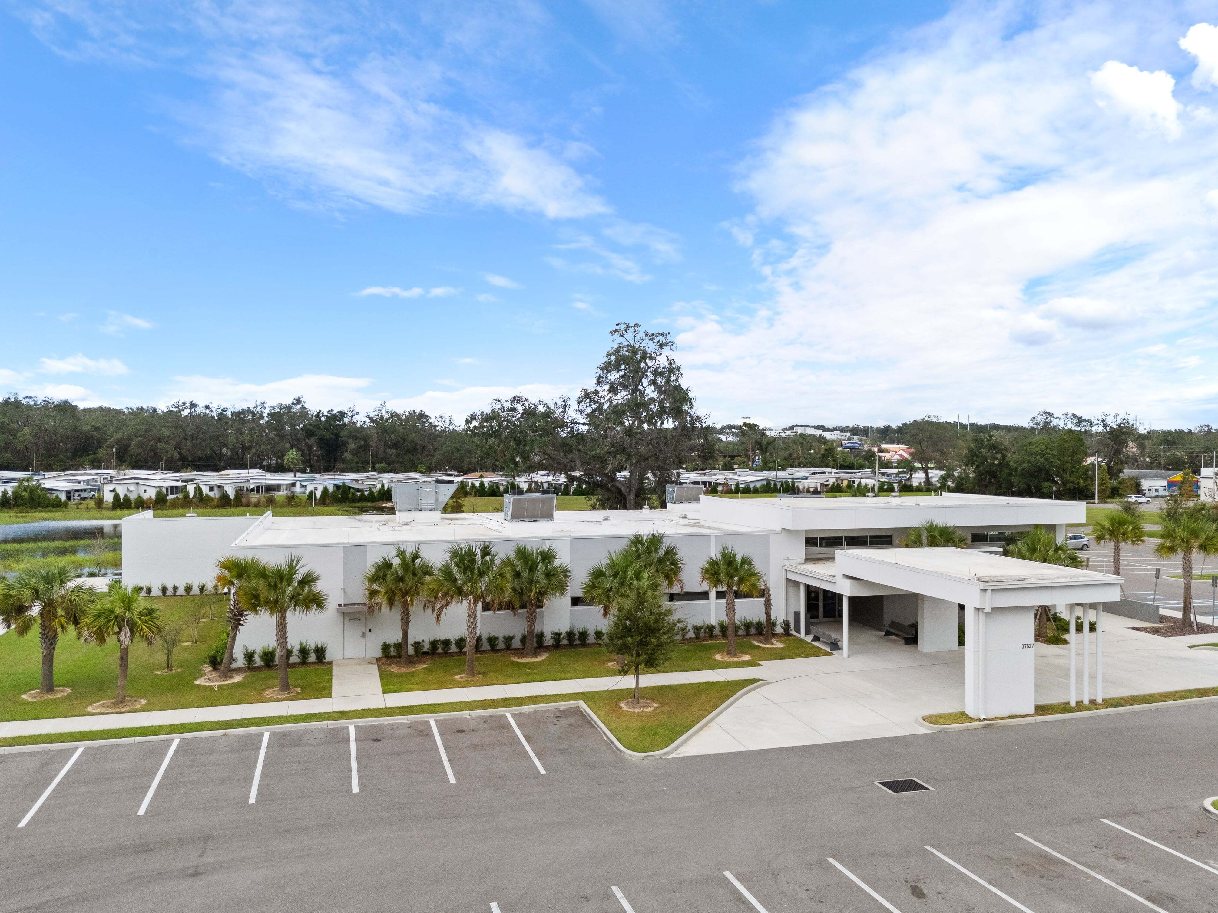 Empty surface lot with painted lines leading to front of VA clinic in Zephyrhills