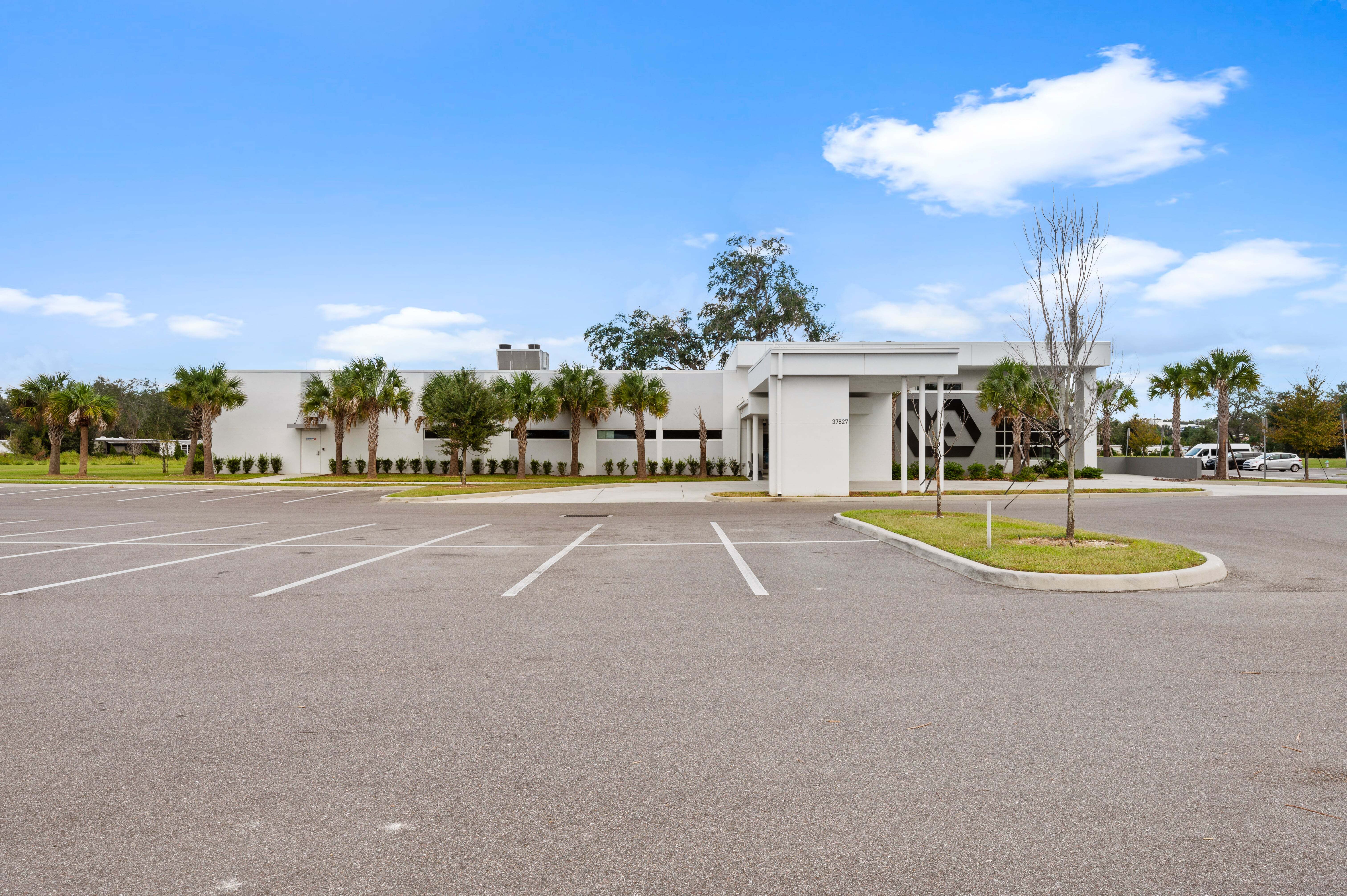 Accessible parking spaces near the clinic with clear striping, ramps, and a view of the main entrance in the background.