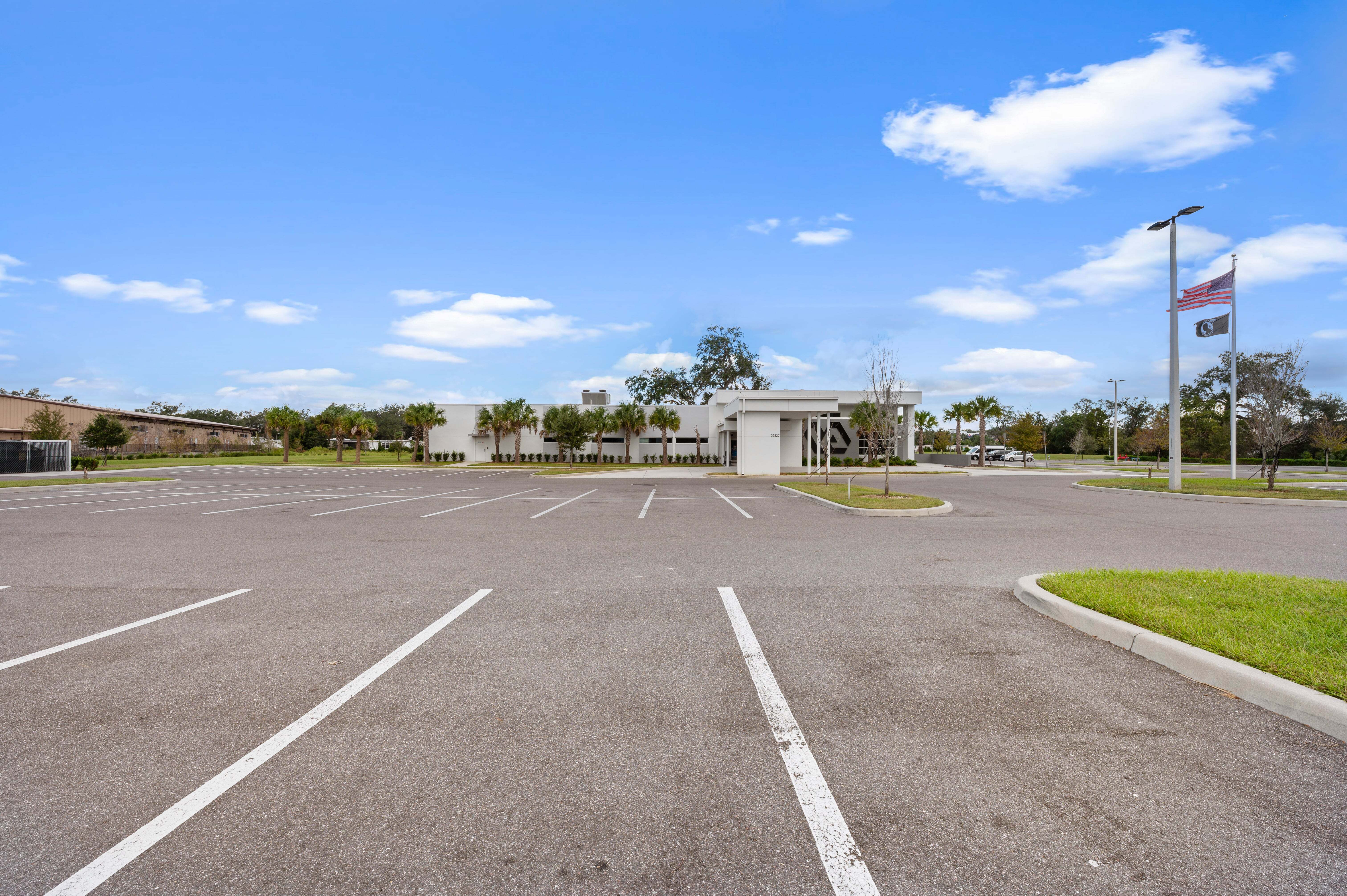 Wide-angle view of the clinic’s parking area showing multiple rows of parked cars, with building signage visible in the distance.